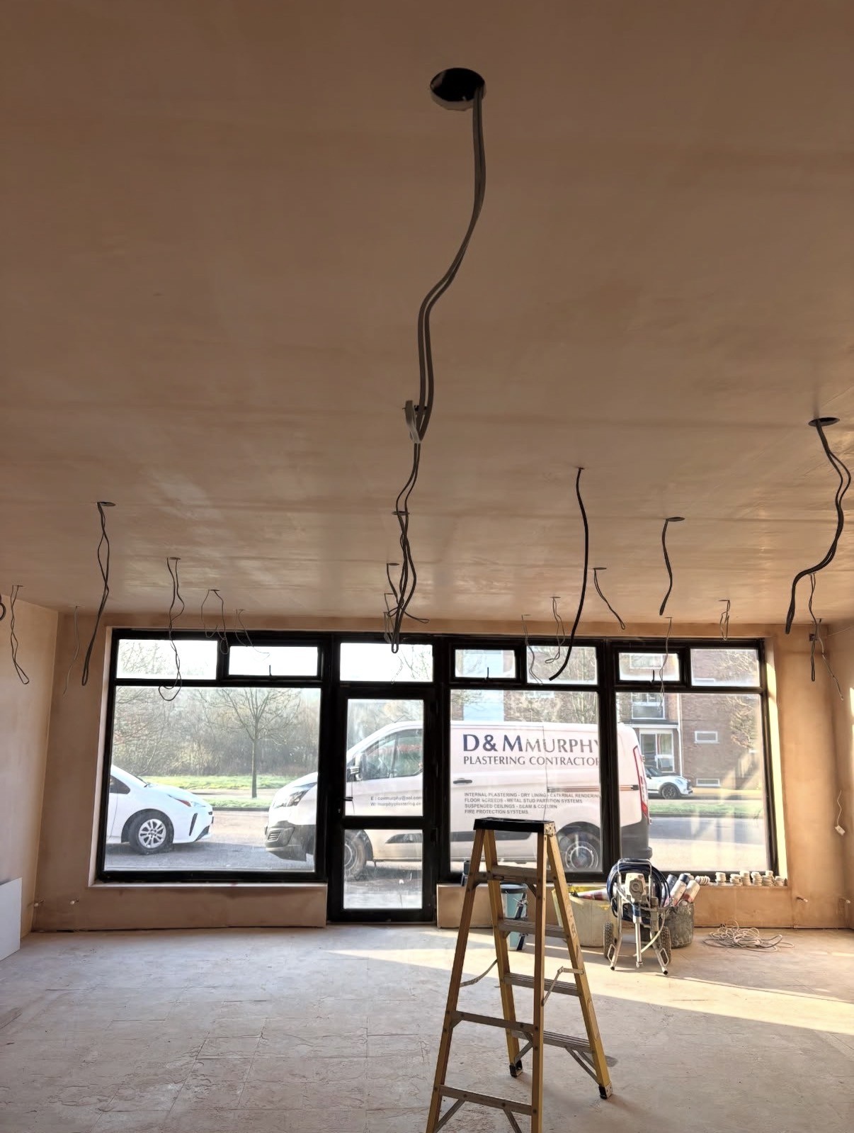 D & M Murphy plastering work — freshly plastered interior with company van visible